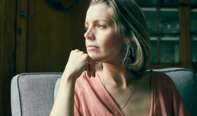 Woman sitting thoughtfully, looking out of a window