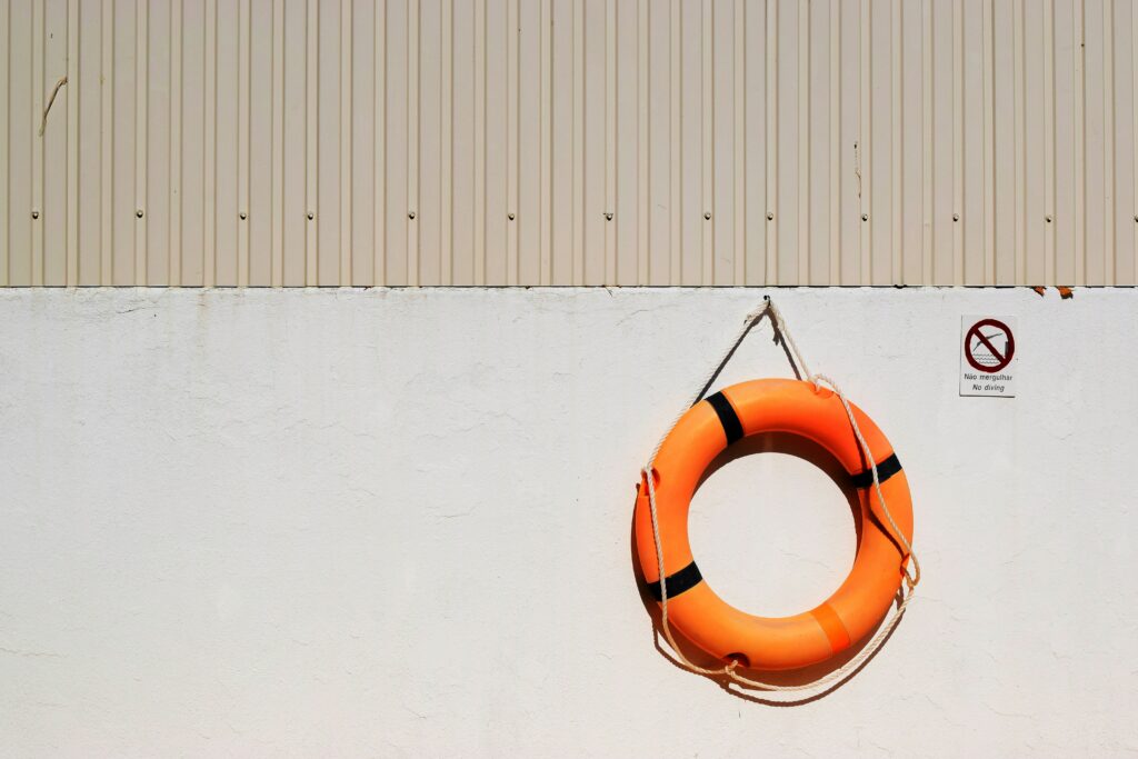 orange life buoy hanging on a beige wall