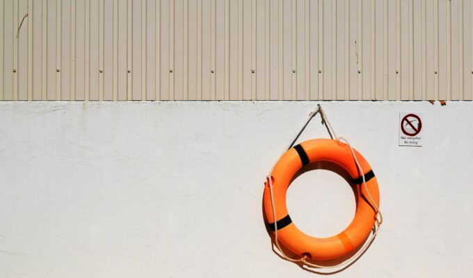orange life buoy hanging on a beige wall