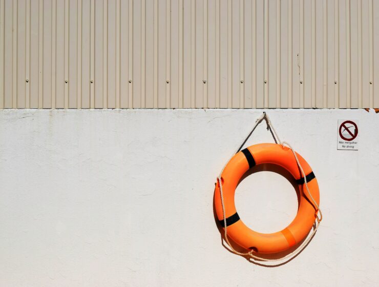 orange life buoy hanging on a beige wall