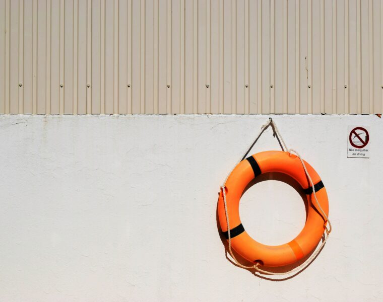 orange life buoy hanging on a beige wall